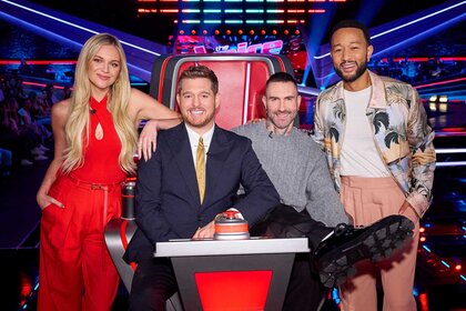 Kelsea Ballerini, Michael Bublé, Adam Levine, and John Legend smiling and posing together on The Voice Season 27, Episode 1.