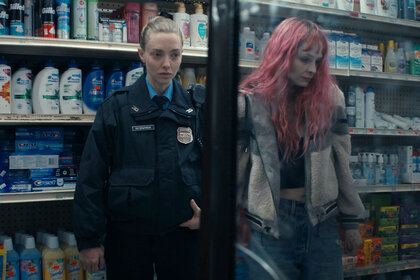 Mickey holds Casey's arm in a drug store in Long Bright River Season 1, Episode 1.