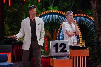 Joe Manganiello and "Dr. Will" Kirby stand behind a #12 briefcase on Deal or No Deal Island Episode 205.