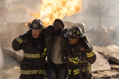 Randy "Mouch" McHolland (Christian Stolte) and Darren Ritter (Daniel Kyri) carry an injured man away from a fire in Chicago Fire Episode 1311.