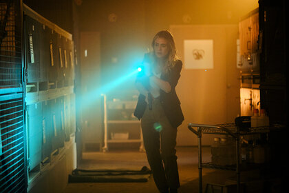 Rebecca Henderson holds flash light up to cages on The Hunting Party Season 1 Episode 1