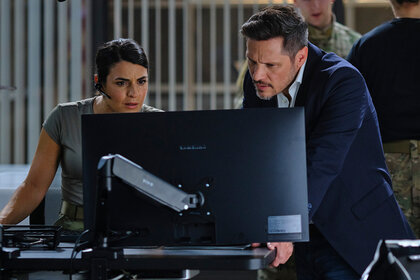 Jennifer Morales and Oliver Odell look at a computer together on The Hunting Party Season 1 Episode 2.