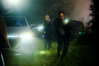 Rebecca Henderson and Jacob Hassani stand outside with flashlights on The Hunting Party Season 1 Episode 5.