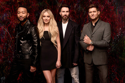 The coaches pose together in front of a dark red backdrop for The Voice Season 27