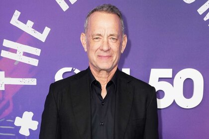 Tom Hanks posing at the SNL50: The Homecoming Concert red carpet.