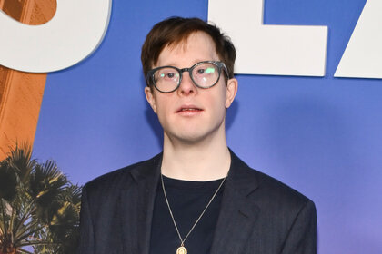 Carson A. Egan poses in glasses and a suit.