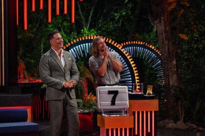 Joe Manganiello and David Genat stand behind a "7" briefcase on Deal or No Deal Island Episode 207.