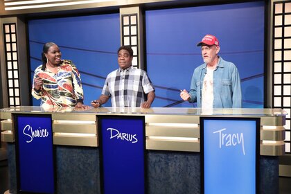 Leslie Jones Tracy Morgan and Tom Hanks standing on a game show set.