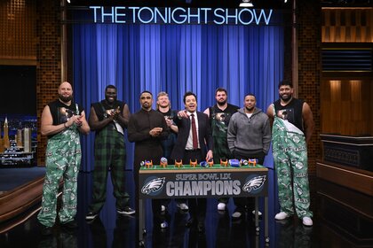 Jalen Hurts, Saquon Barkley, and the Eagles' Offensive Linemen stand behind a game with Jimmy Fallon on The Tonight Show Starring Jimmy Fallon Episode 1270.