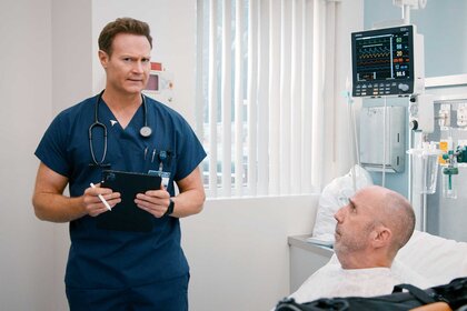 Dr. Bruce in a hospital room with Jonathan on St. Denis Medical Season 1, Episode 12.