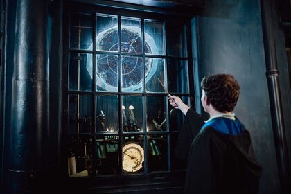 A guest holding up a wand in Universal Orlando's The Wizarding World of Harry Potter.