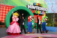 Shigeru Miyamoto and Scott Strobl pose for portrait with Princess Peach, Mario, and Luigi characters during the Grand Opening Day of "SUPER NINTENDO WORLD" at Universal Studios