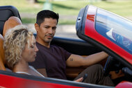 Thomas Magnum (Jay Hernandez) and Juliet Higgins (Perdita Weeks) sit in the red corvette