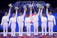 The 2024 Us Olympic Womens Gymnastics Team hold up flowers after the last day of trials