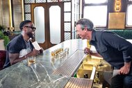 Kevin Hart and Seth Meyers laugh together at a bar during day drinking