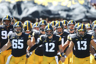 Quarterback Cade McNamara of the Iowa Hawkeyes leads the team onto the field before the first half against the Utah State Aggies