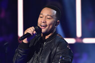 John Legend perform on stage in a leather jacket in 2017