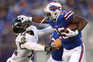 Running back LeSean McCoy #25 of the Buffalo Bills stiff arms strong safety Eric Weddle #32 of the Baltimore Ravens