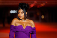 Taraji P. Henson posing on a red carpet in a purple gown.