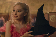 Ariana Grande as Glinda holding a witches hat in WICKED.