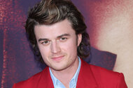 Joe Keery standing in front of a step and repeat.