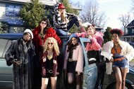 The women of Saturday Night Live wear fur coats and pose near a blue car on Episode 1669.