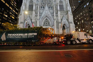 The Rockefeller Center Christmas Tree arrives at night to Rockefeller Center with St. Patrick's Cathedral in the background on November 08, 2024 in New York City.