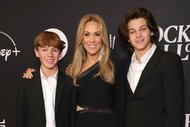 Levi Crow, Sheryl Crow and Wyatt Crow pose together in black outfits.