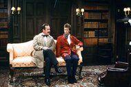 Inspector Langley (Phil Hartman) and Sir Jeffrey Kurr (Dana Carvey) sit on a sofa together during an SNL sketch.