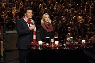 immy Fallon and Saoirse Ronan wear striped Christmas sweaters and stand in front of candles.