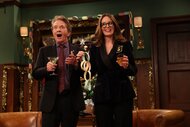 Martin Short and Tina Fey holding a paper chain decoration while smiling.