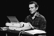 Bill Murray sits at a desk with a type writer during a sketch on Saturday Night Live