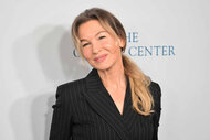 Renee Zellweger smiles in a black blazer.