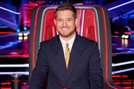 Michael Bublé smiling in the coaches chair on The Voice Season 27, Episode 1.