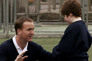 Peyton Manning crouches to talk to a child on SNL Episode 3216.