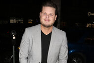 Derrick Levasseur wears a grey blazer over a black shirt outside