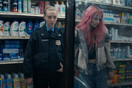 Mickey holds Casey's arm in a drug store in Long Bright River Season 1, Episode 1.