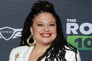 Michelle Buteau smiling in front of a step and repeat.