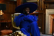 Bob The Drag Queen wears a full cobalt blue outfit with a large hat on The Traitors Episode 301.