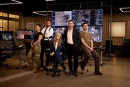 The cast of The Hunting Party poses together in an office with multiple screens for Season 1.