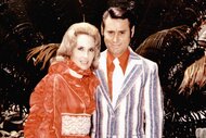 Tammy Wynette and George Jones posing together and smiling in 1960.