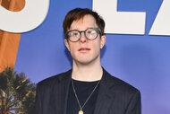 Carson A. Egan poses in glasses and a suit.