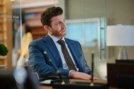 Rick Dodson (Bryan Greenberg) sits at a desk in a blue suit on Suits LA Episode 101.