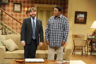 Zach Galifianakis and Kenan Thompson stand in a living room during a sketch on Saturday Night Live Season 38, Episode 19