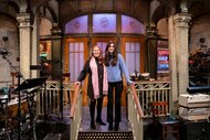 Mother Sylvia Cerel-Suhl and daughter Sarah Suhl smiling on stage during the Saturday Night Live Super Fan Studio Tour.