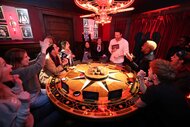 Contestants surrounding a round table during The Traitors Experience.