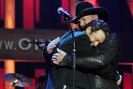 Blake Shelton hugging Trace Adkins on stage during Country Comes Home: An Opry Celebration.