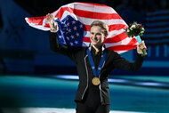 Ilia Malinin holds the american flag up on the ice after winning the Men's Free Program during the ISU World Figure Skating Championships