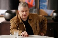 Patton Oswalt sitting at a desk on Suits LA Season 1, Episode 3.