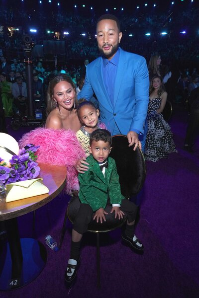 Chrissy Teigen, Luna Stephens, Miles Stephens, and John Legend posing at the Grammy Awards.